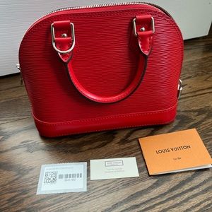 New, never used, red (coquelicot) alma bb in epi cuir with matching strap
